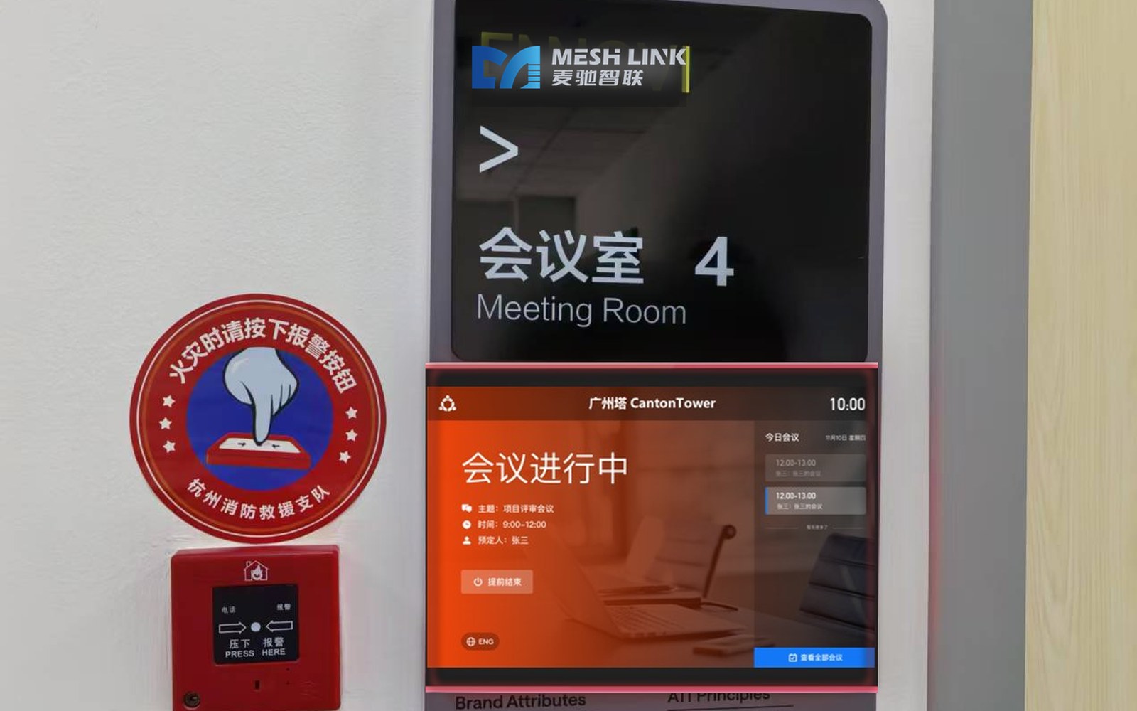 麦驰智联会议室智能屏实景安装效果（门侧墙面安装，会议进行中红色状态灯带，品牌 LOGO 展示）